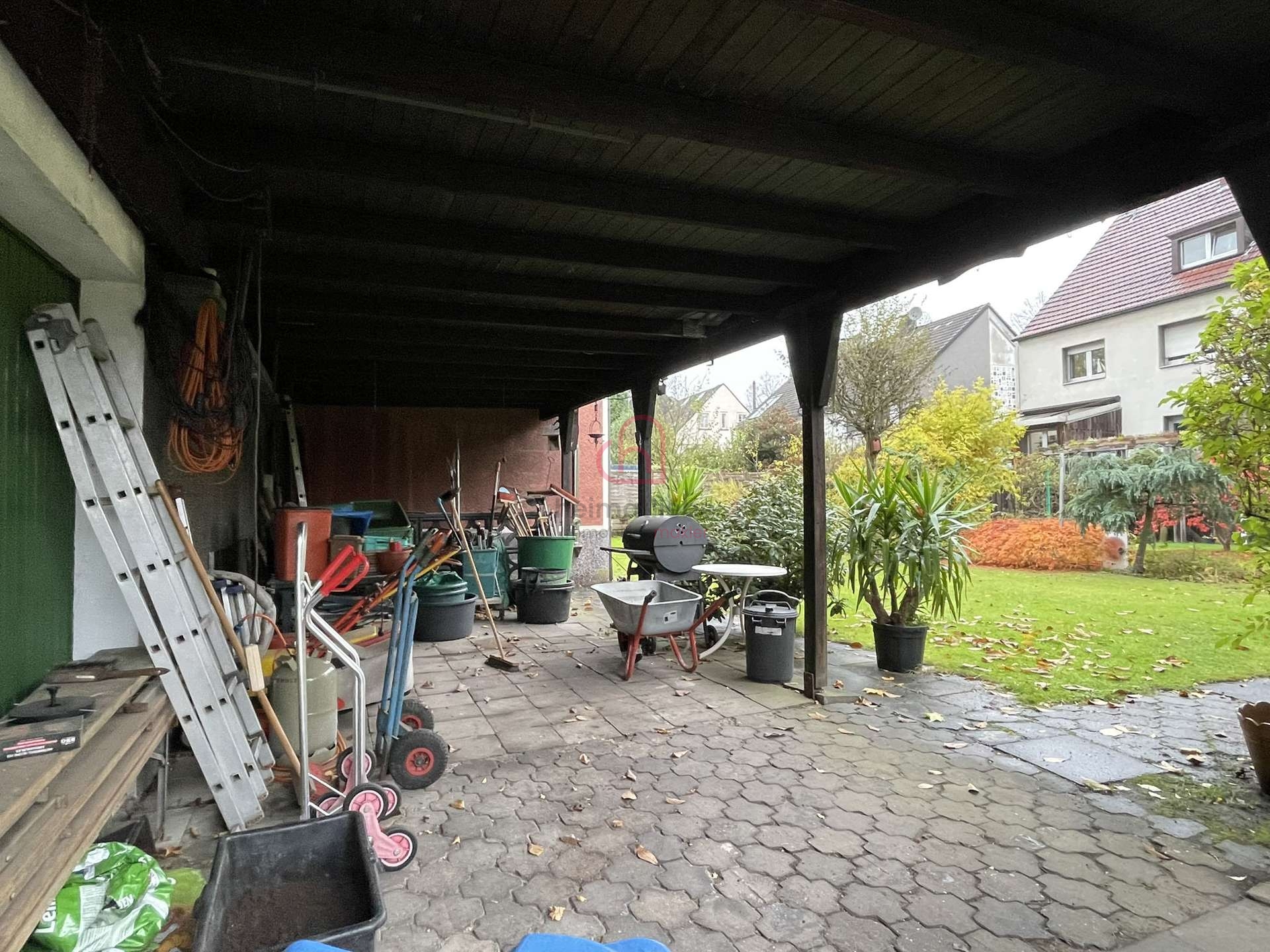 Gepflasterter Unterstand mit Remise